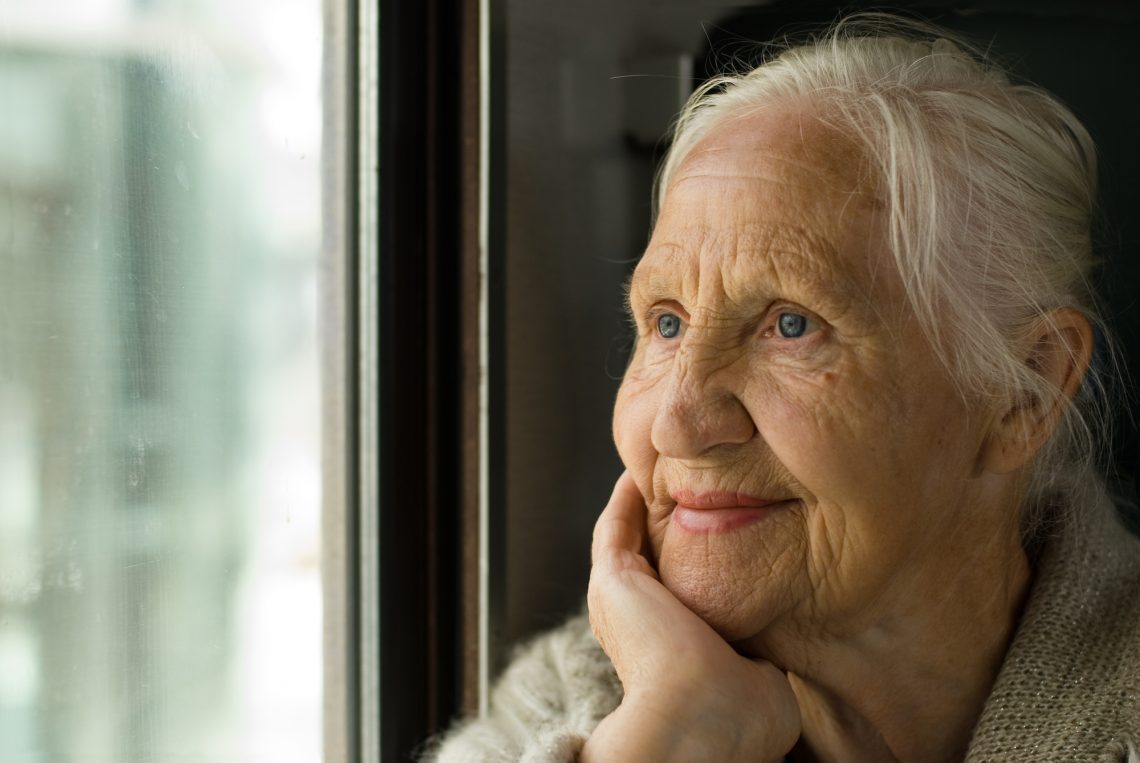 Adorável avó olhando em uma janela, em um trem 