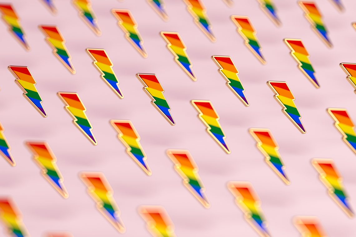 Blurry closeup shot on LGBT lightning bolt rainbow pride symbol isolated on pink background. Gay, Lesbian and sexual minority fight for their rights symbol concept. 3D rendering