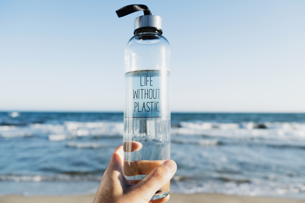 Фото пластиковой бутылки с водой на фоне моря