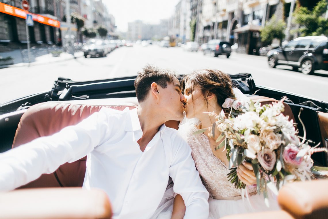 Молодожены целуются в кабриолете фото