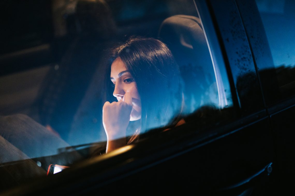 Фото молодой женщины со смартфоном в машине