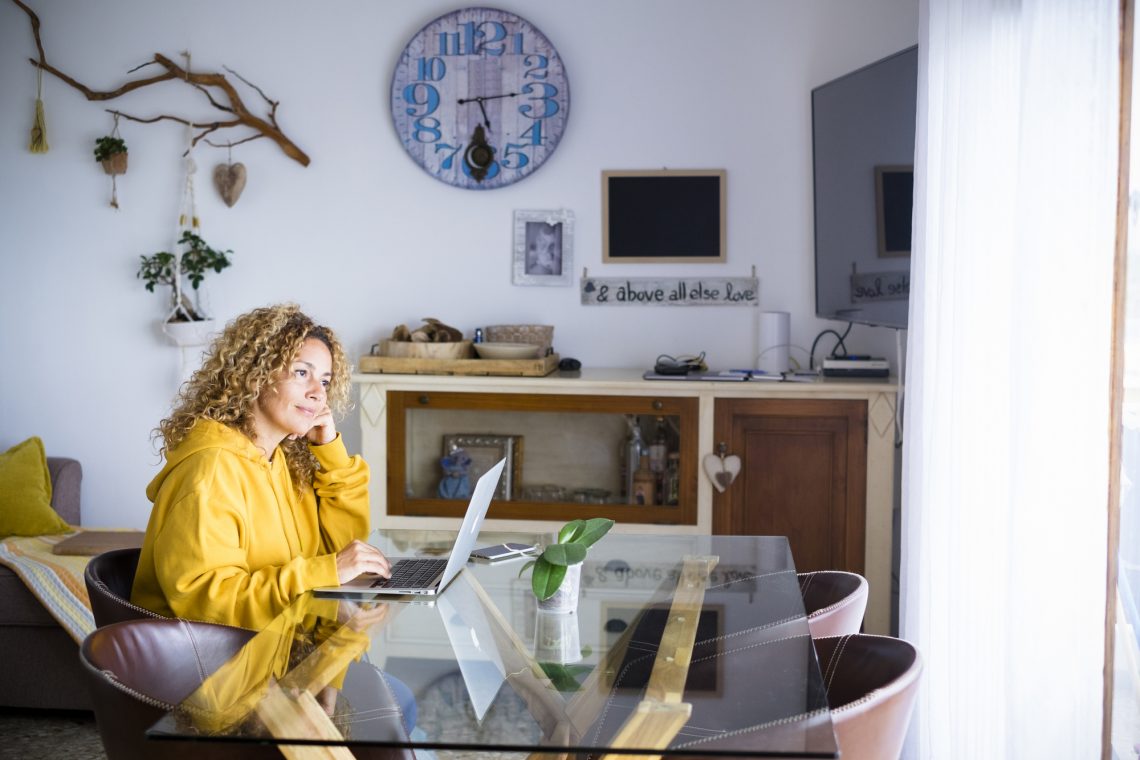 Фото женщины, которая работает дома за ноутбуком