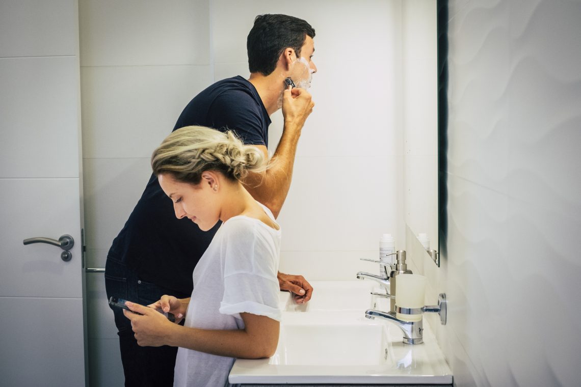 Фото бреющегося мужчины и женщины, которая пользуется смартфоном