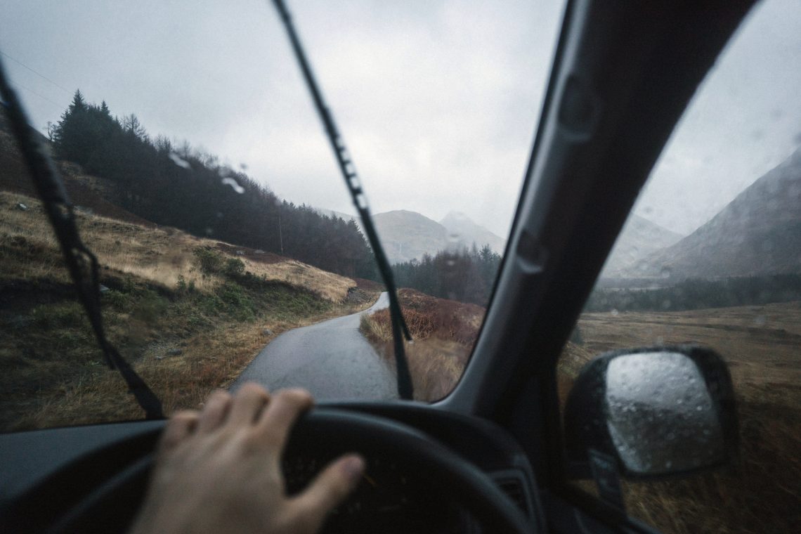 Мужчина едет за рулем в дождливую погоду фото