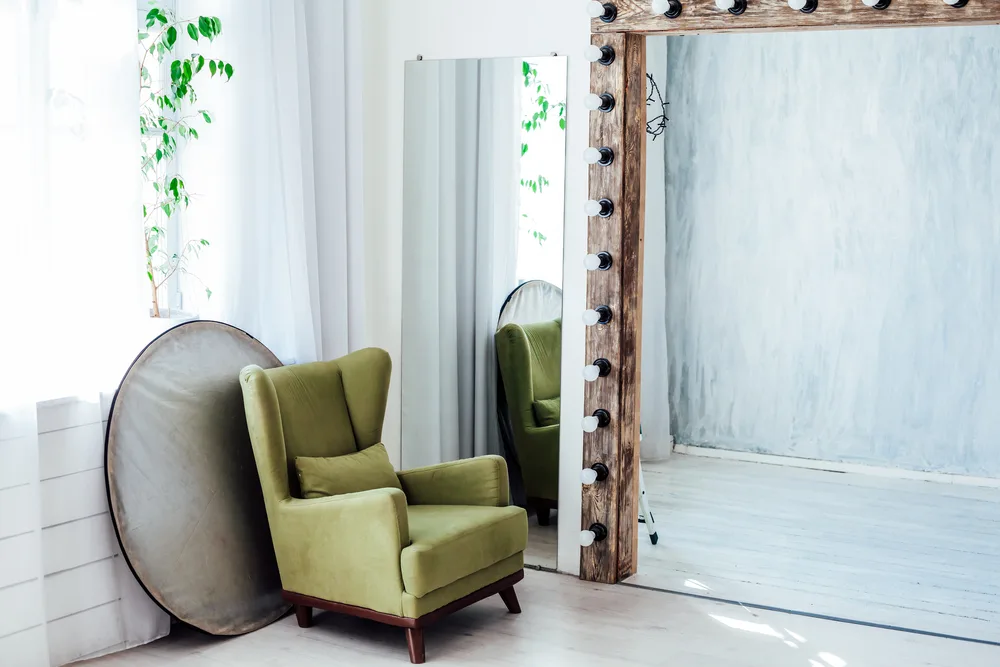 Фото зеленое кресло зеркало и отражатель в белой фотостудии