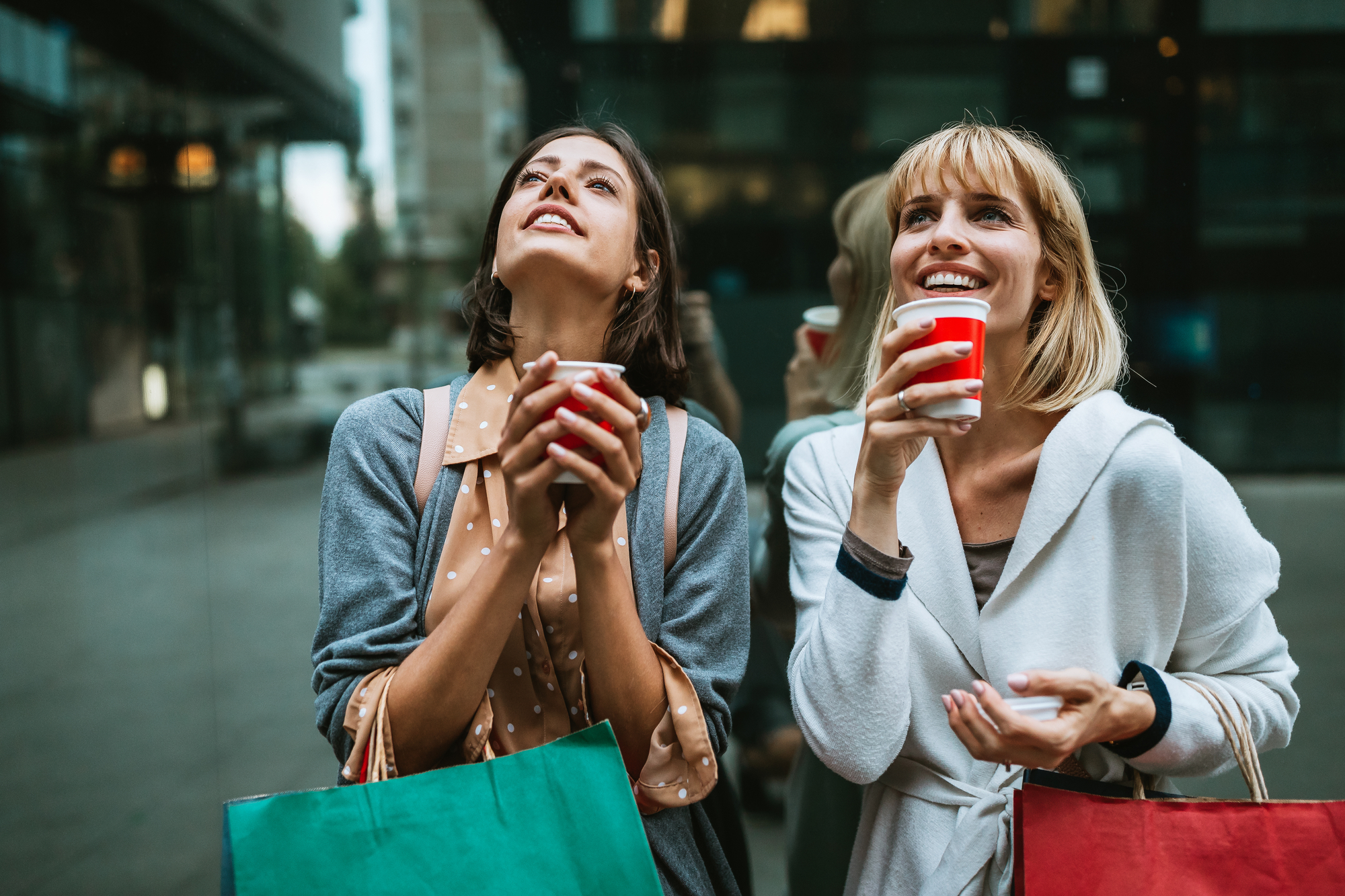Фото две женщины с кофе на шопинге в городе
