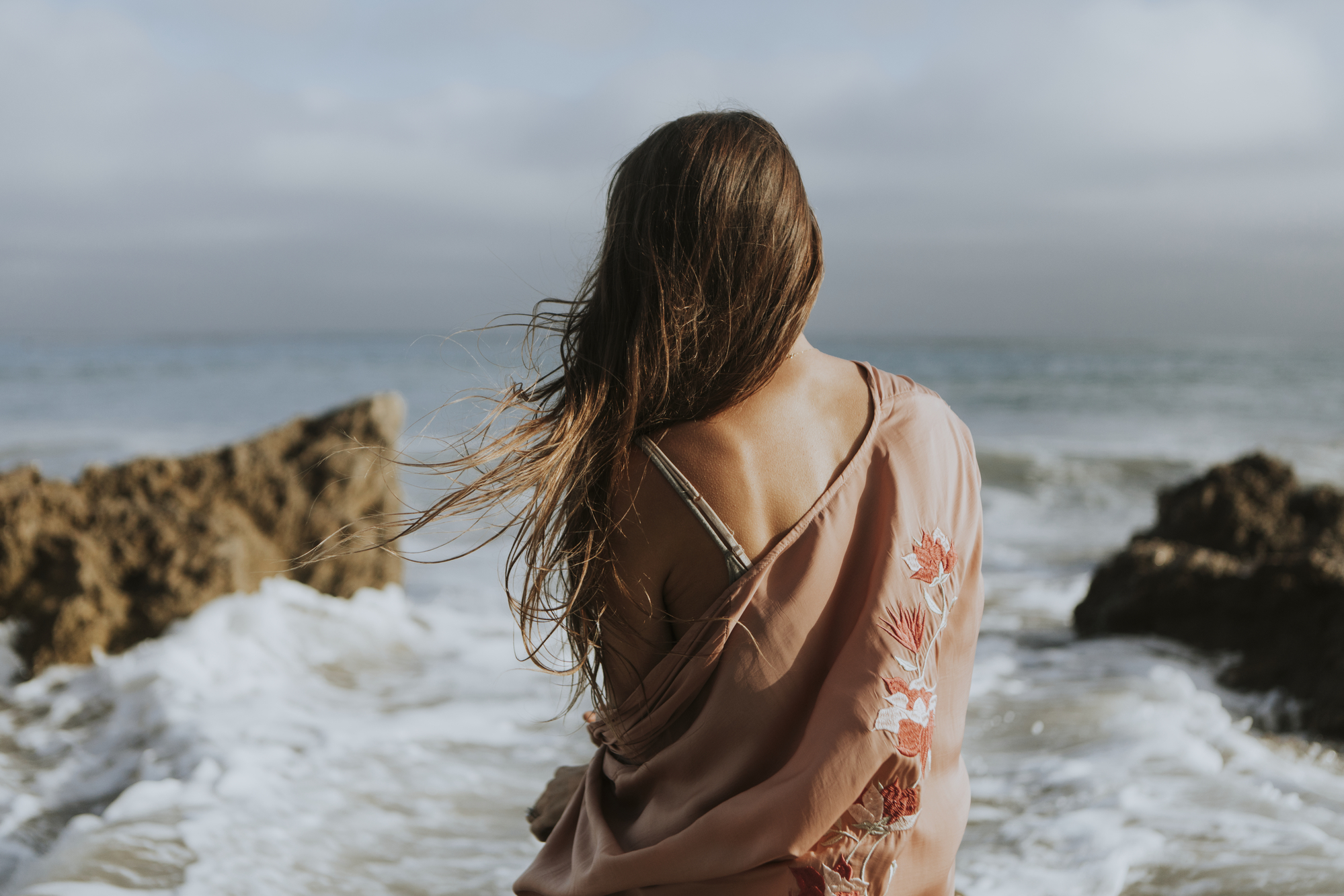 Фото жінка зі спини біля моря