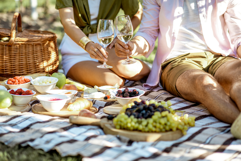 Фото пара на пікніку з шампанським і фруктами