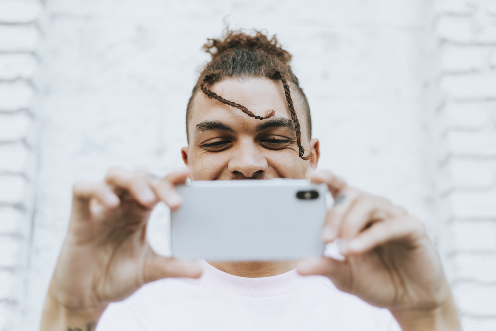 Фото темношкірий хлопець зі смартфоном 