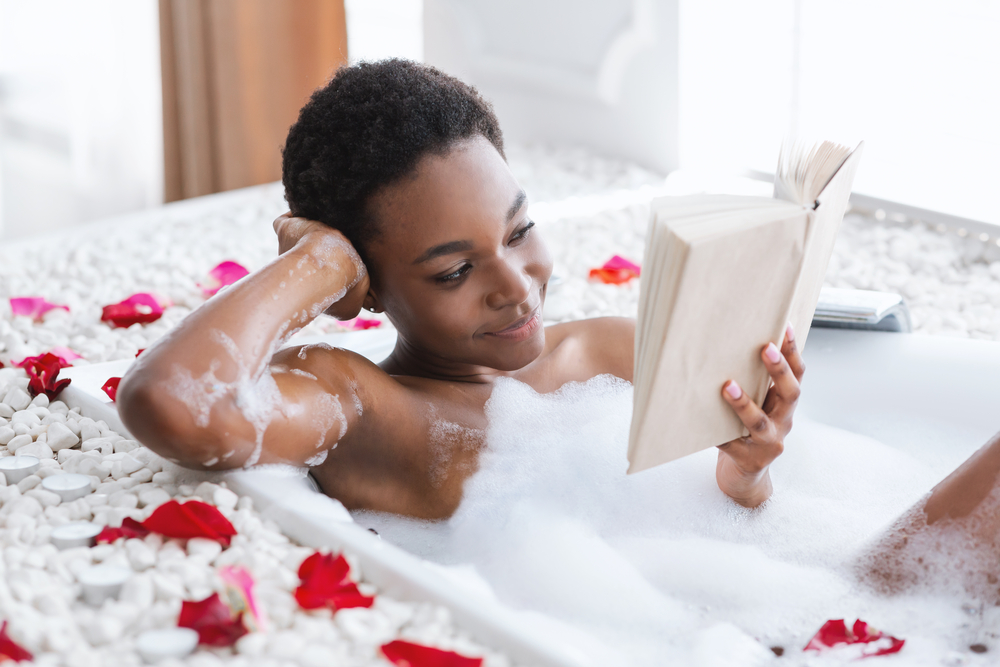 Фото чорна жінка читає у ванні