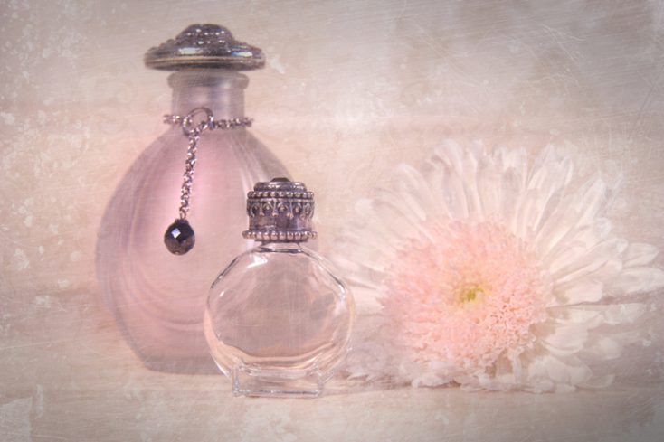 Vintage perfume bottles with flower © Depositphotos