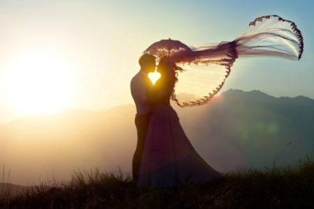 The groom and the bride kiss in mountains against a decline. | Stock Photo © Depositphotos