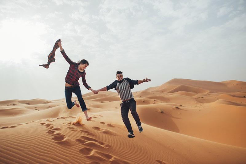Couple of travelers in desert Sahara