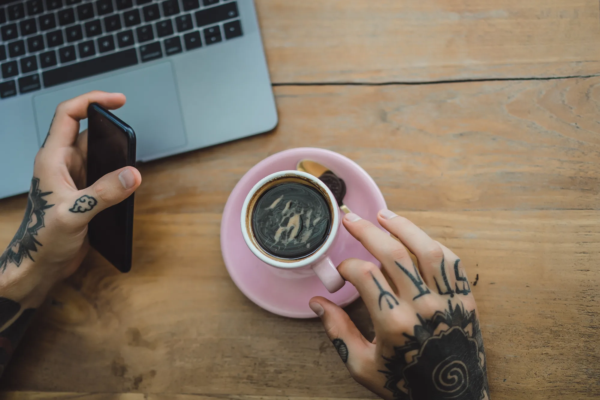 image of tattooed hands, coffee and laptop