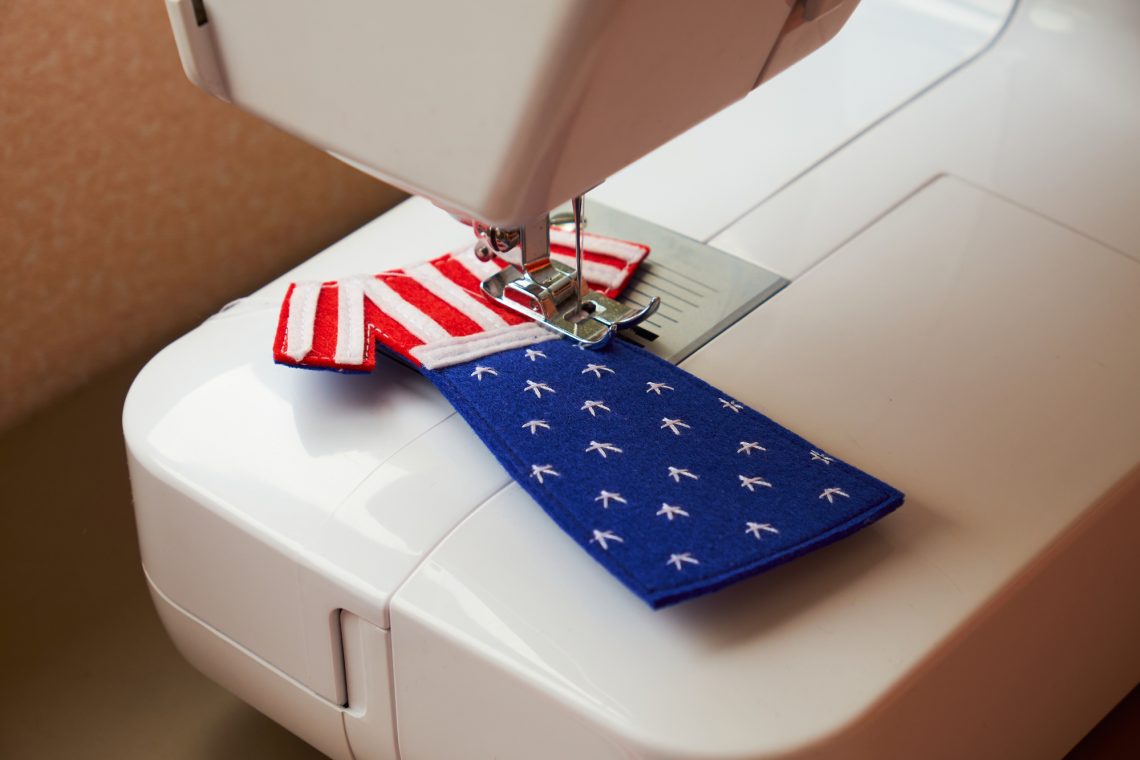 The process of sewing felt toy dress with American flag stock photo