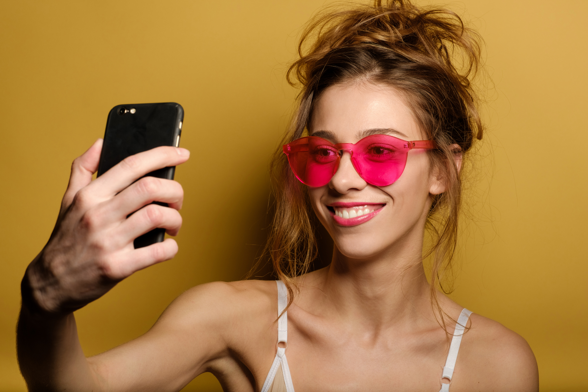 Funny portrait of a smiling young girl in pink glasses stock photo