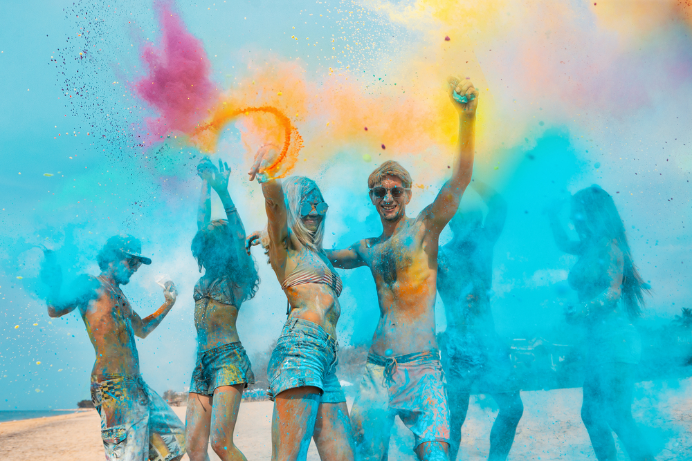 Фотографія молоді люди обсипаються сухими фарбами на фестивалі Холі