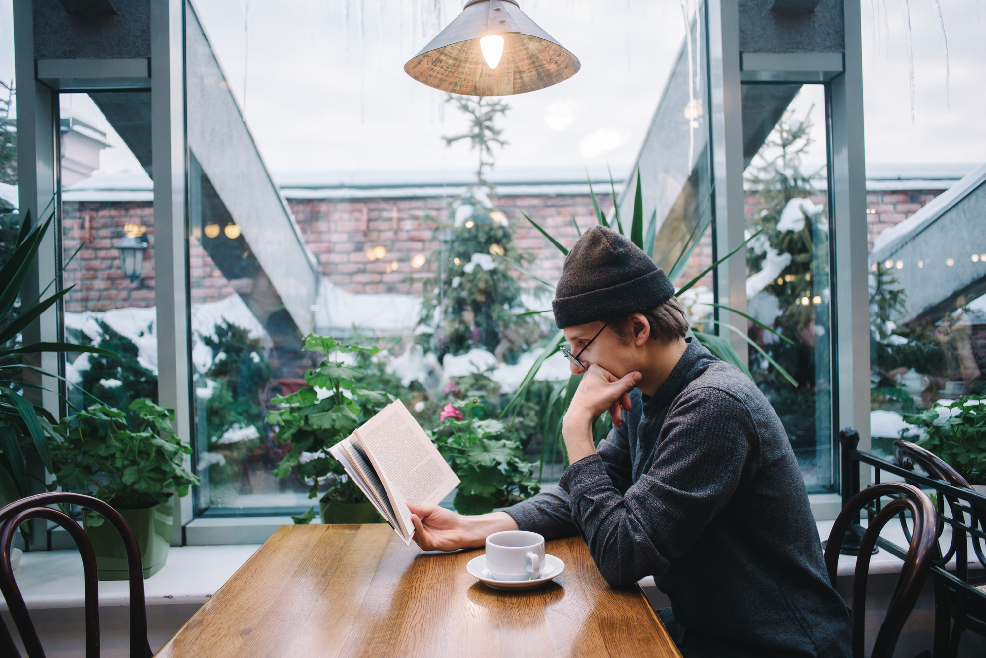 Um jovem estudante lendo um livro sozinho