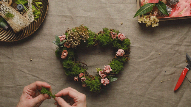 Mãos decora a guirlanda floral para o dia de São Valentim