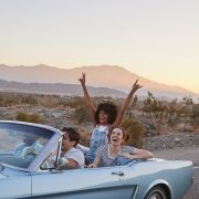 Group Of Friends On Road Trip Driving Classic Convertible Car stock image