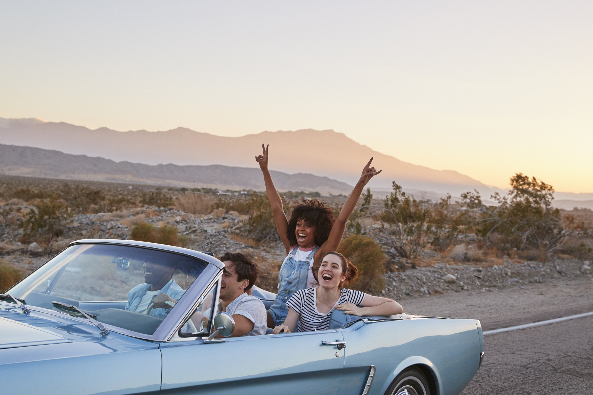 Group Of Friends On Road Trip Driving Classic Convertible Car stock image
