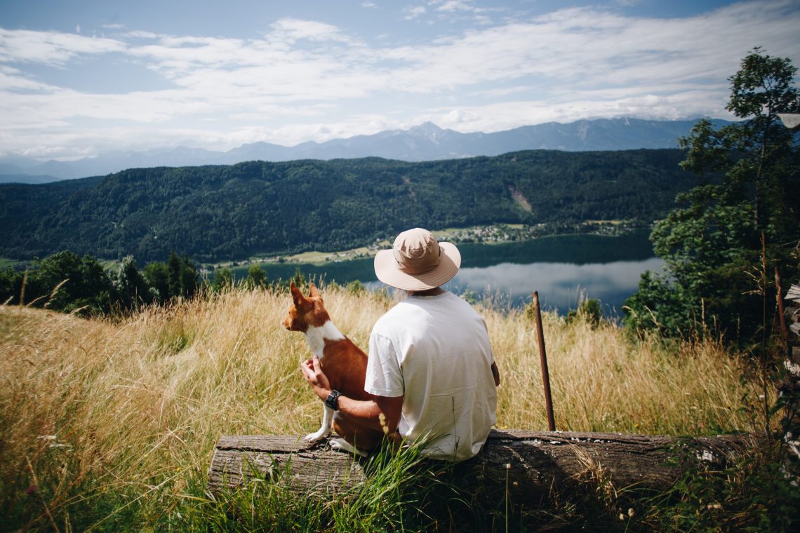 Man in hat sits with best friend dog puppy at top