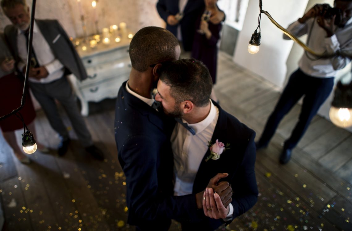 Newlywed gay couple groom dancing