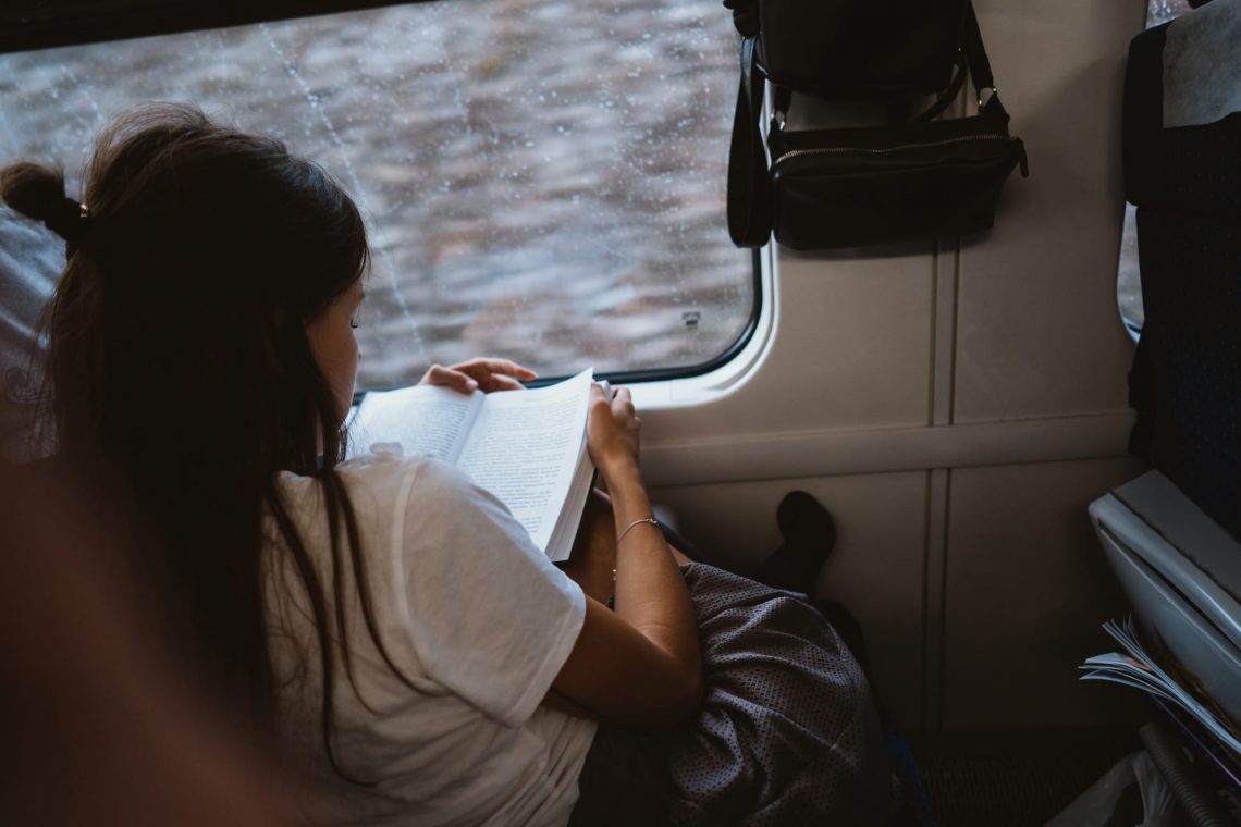 Фотографія дівчини з книгою у поїзді