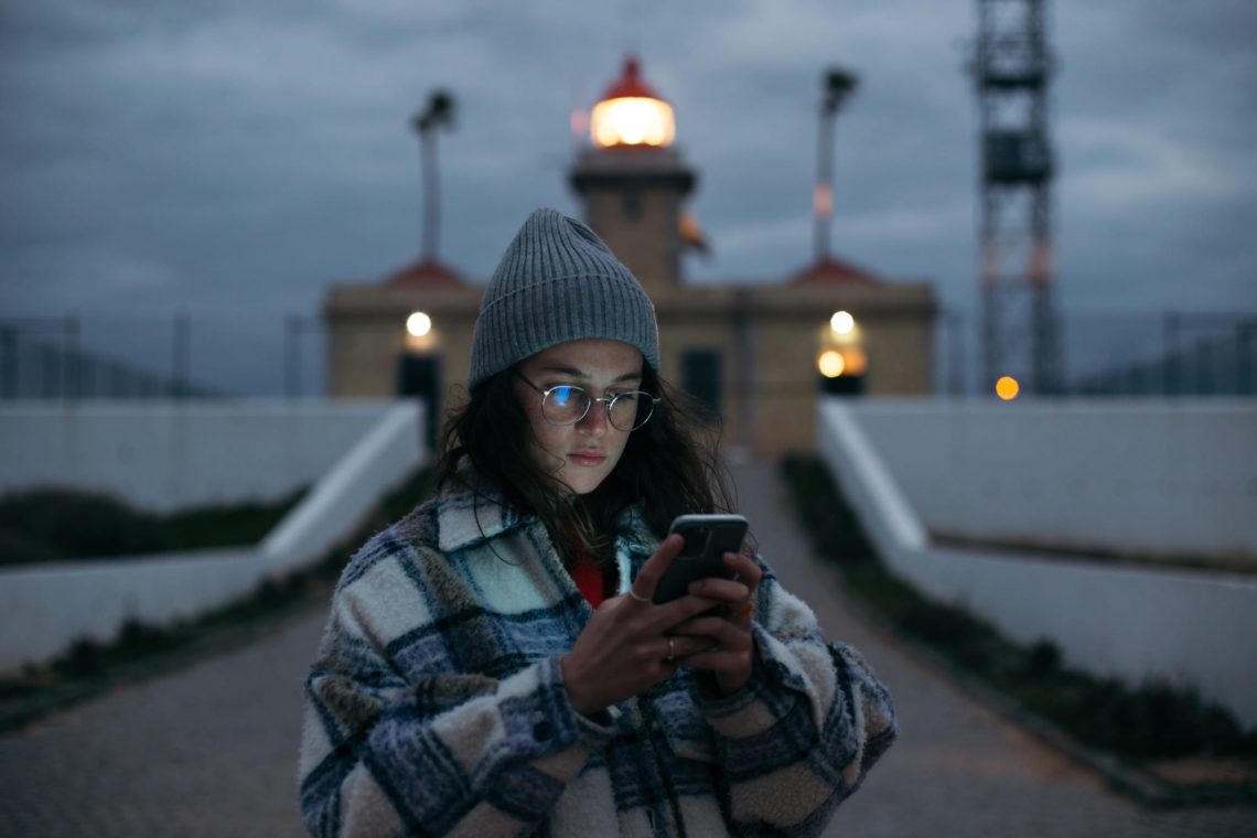 Фотографія дівчина з мобільним телефоном в осінньому одягу
