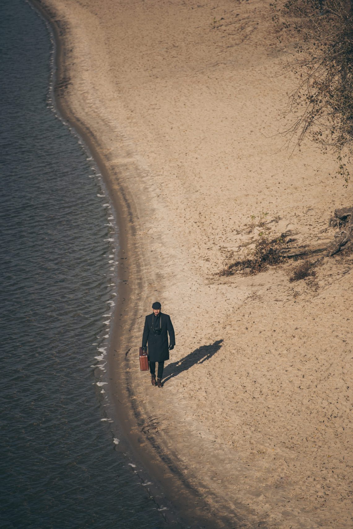 Фотографія чоловік з валізою на осінньому пляжі