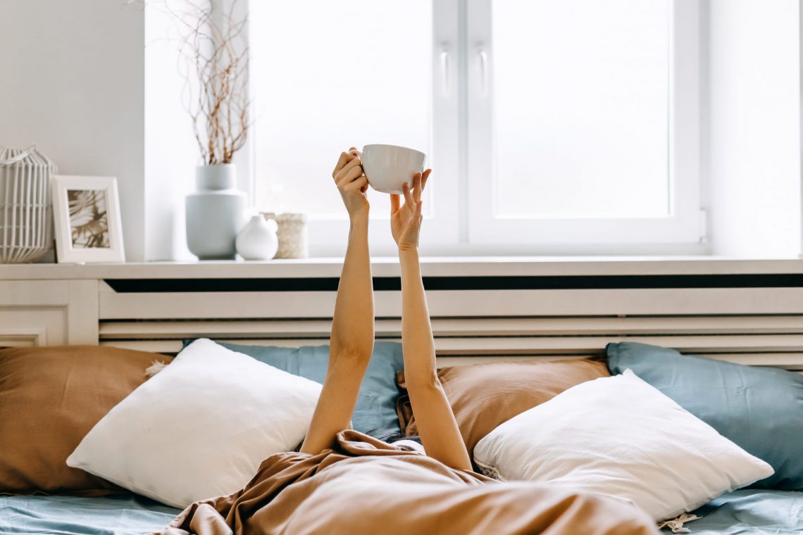 Фотографія жінка з чашкою кави у ліжку