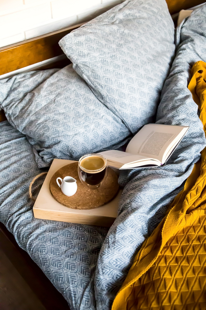 Фотографія піднос з кавою і книжка в ліжку