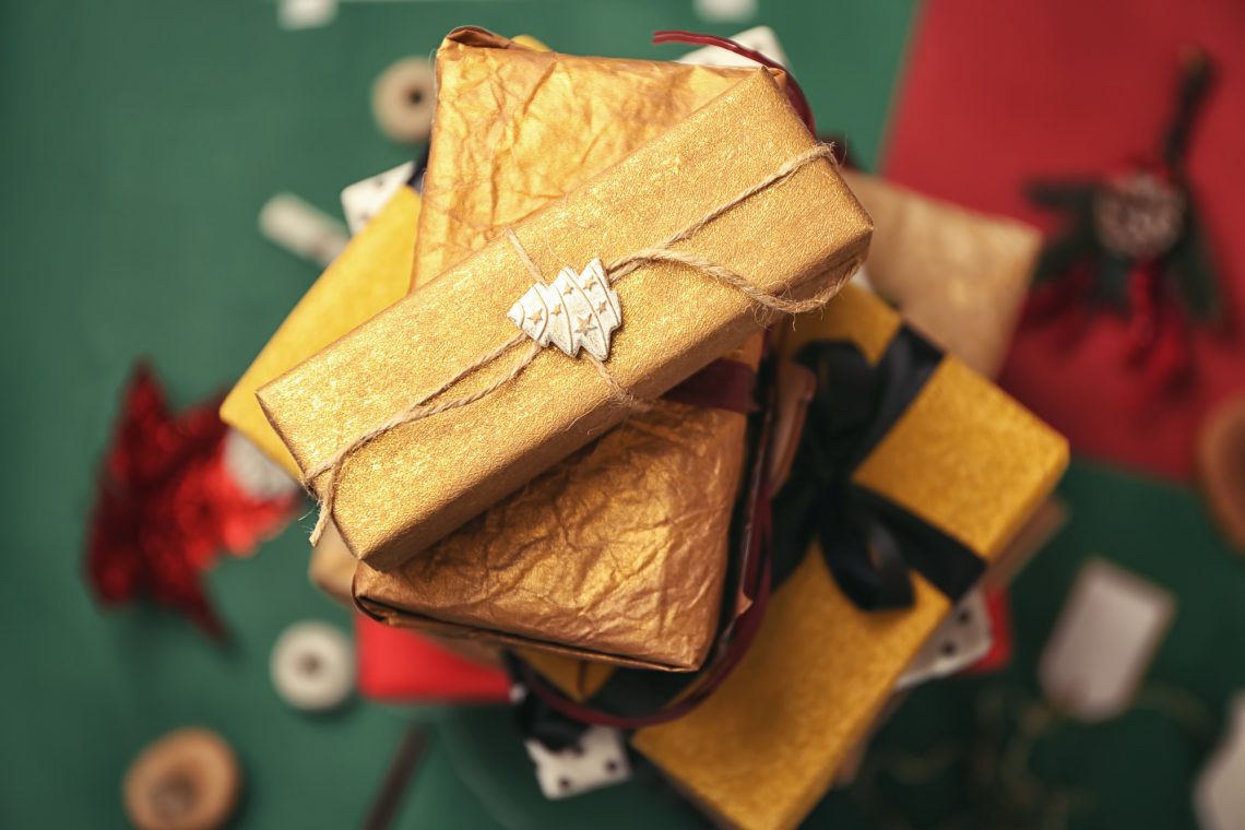 Stack of beautifully decorated gift boxes on color background, top view
