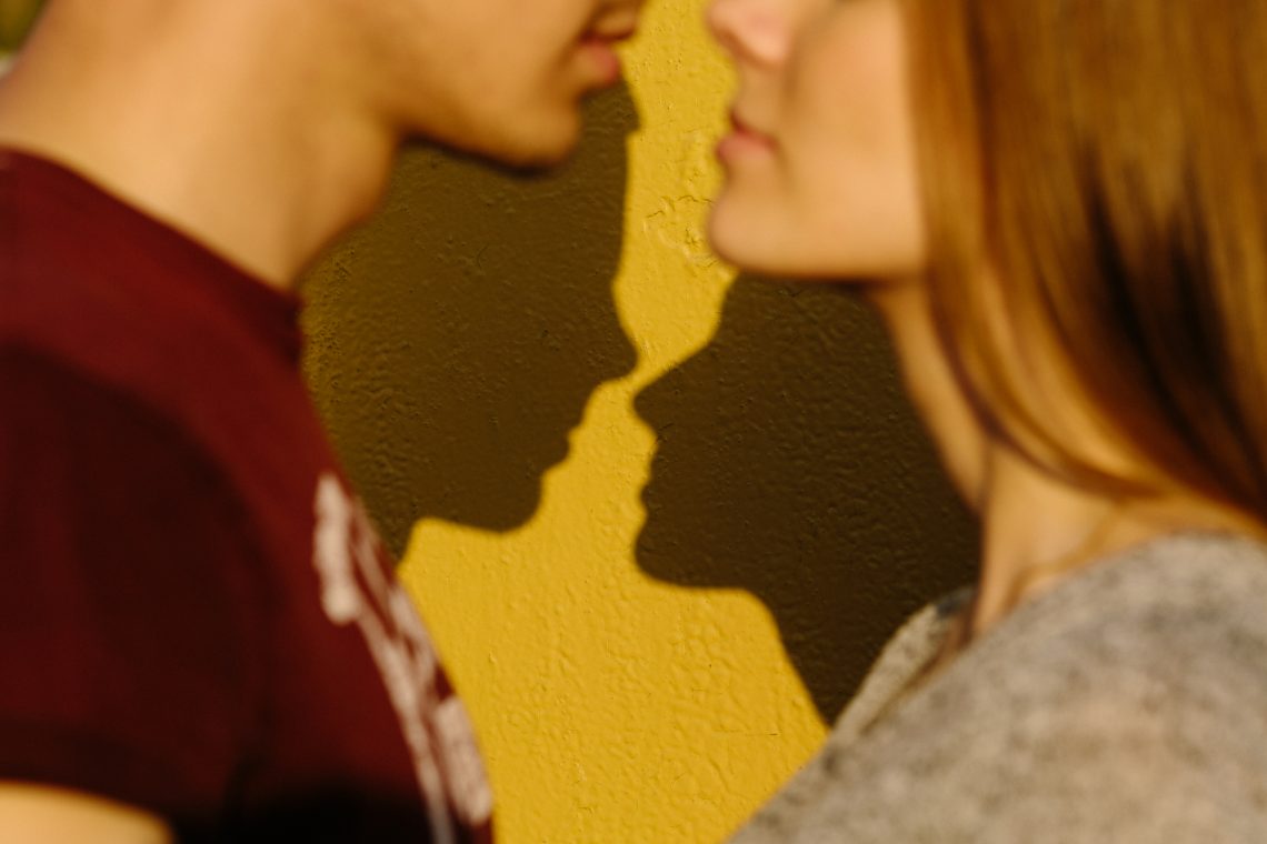 Silhouette couple in love with shadows on a yellow isolated background