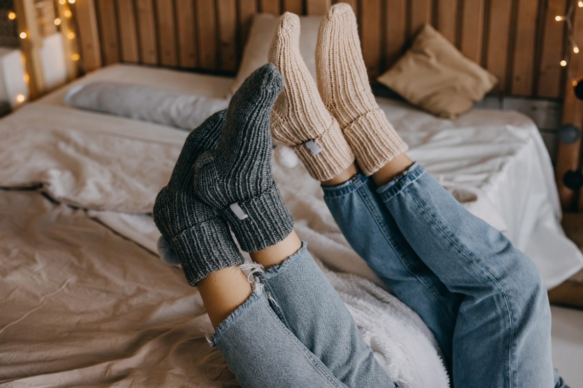 Closeup of two women’s feet in warm wool knitted socks.