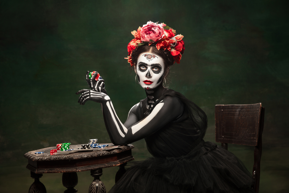 Young girl in the image of Santa Muerte, Saint death or Sugar skull with bright make up. Portrait isolated on studio background.
