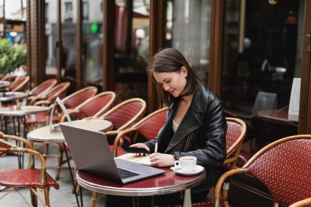 Фотографія жінка працює на ноутбуці в кафе
