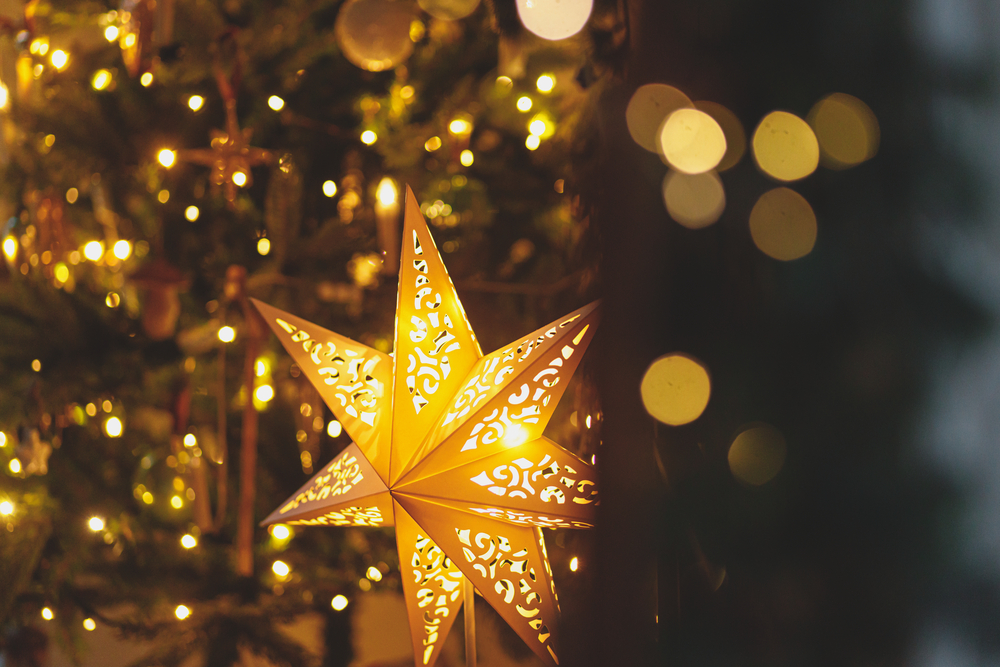 Фото різдвяна ілюмінована зірка, ялинка із золотими вогниками