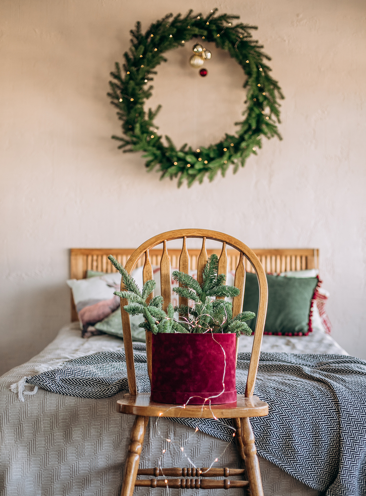 Фото спальня декорована різдвяним вінком і гілками ялинки до Різдва
