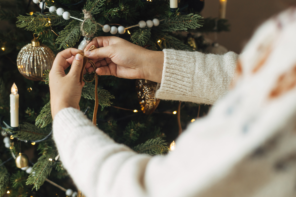 Фото жінка прикрашає різдвяну ялинку