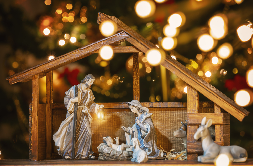 Фото сцена Різдвяних ясел з фігурками Ісуса, Марії, Йосипа та овечок