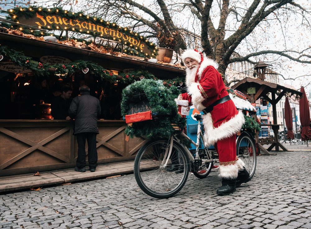 Santa Claus drives a decorated bicycle with gifts in Munich.