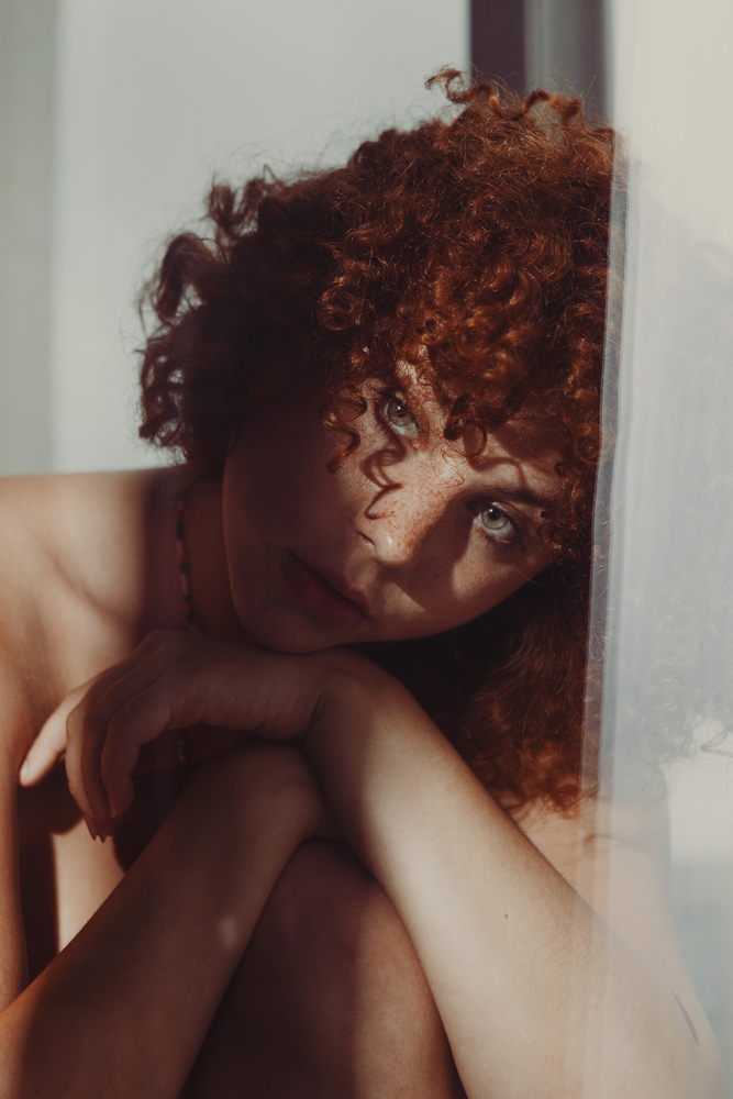 Photo portrait of a young woman with red curly hair