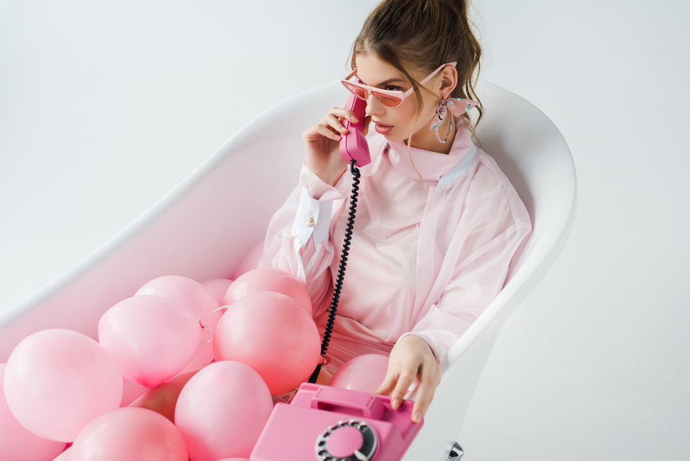Фото дівчина з телефоном у ванні з рожевими кульками 