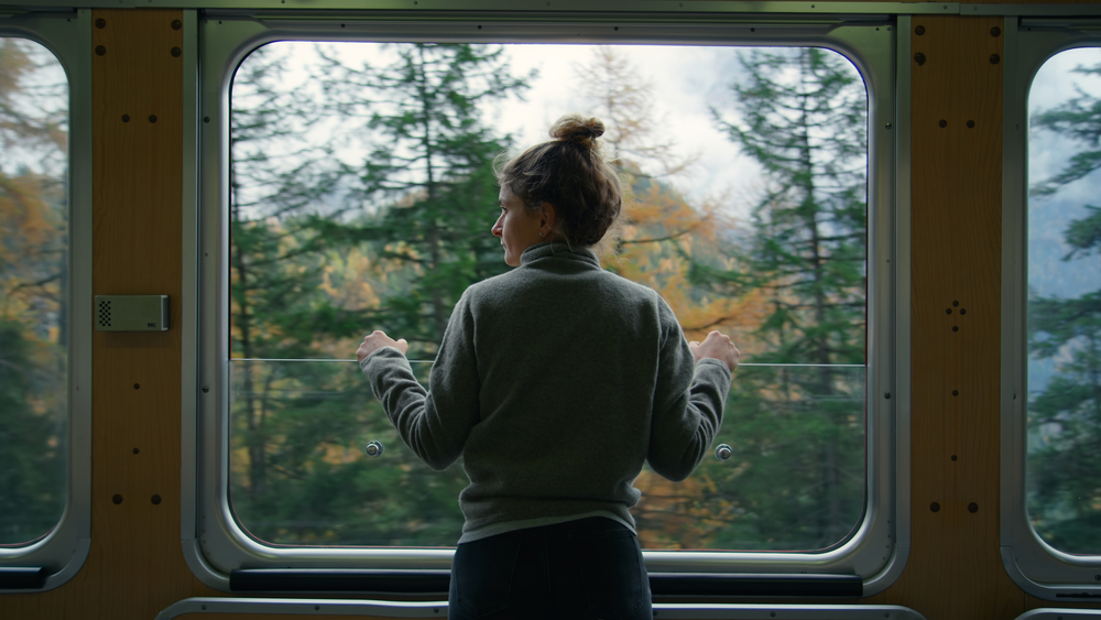 Young female traveler on tourist train in mountain
