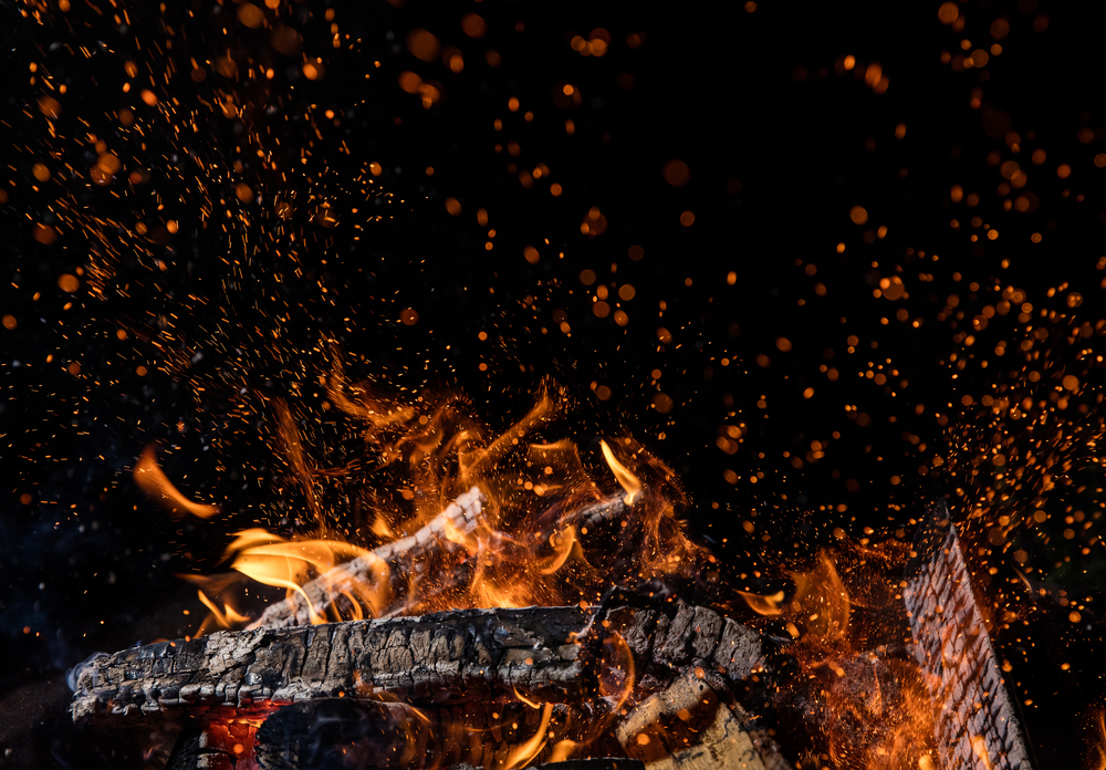 Фото палаючі дерев'яні колоди у вогні, багаття ізольоване на чорному тлі