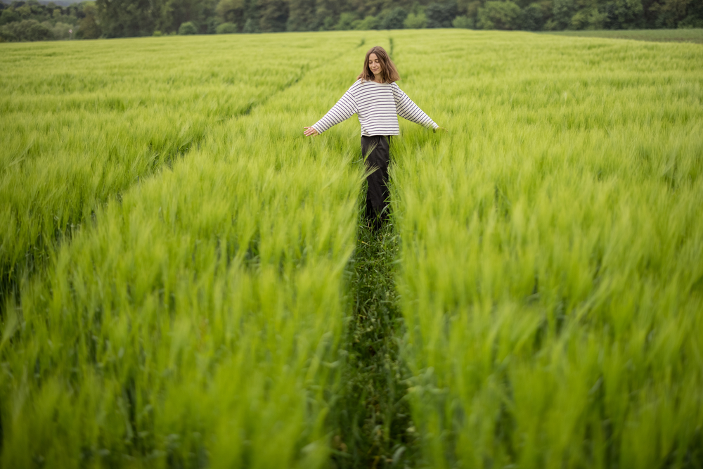 Фото молода жінка стоїть у зеленому полі