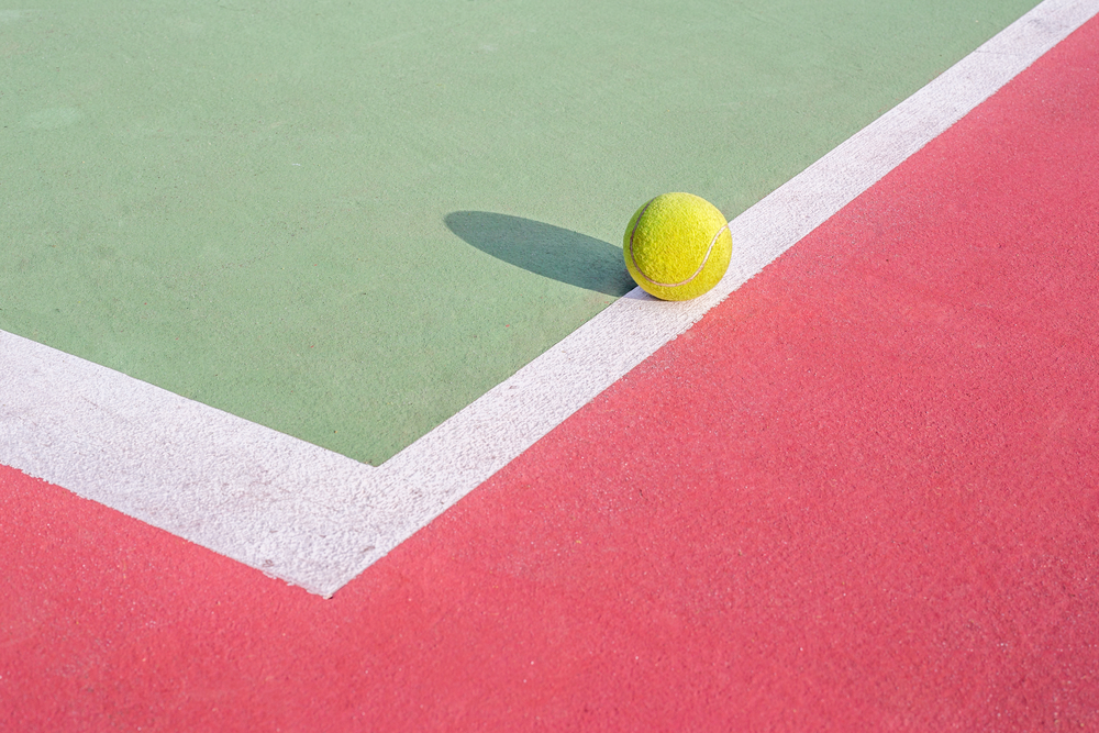 Photo green tennis ball on white line of tennis court